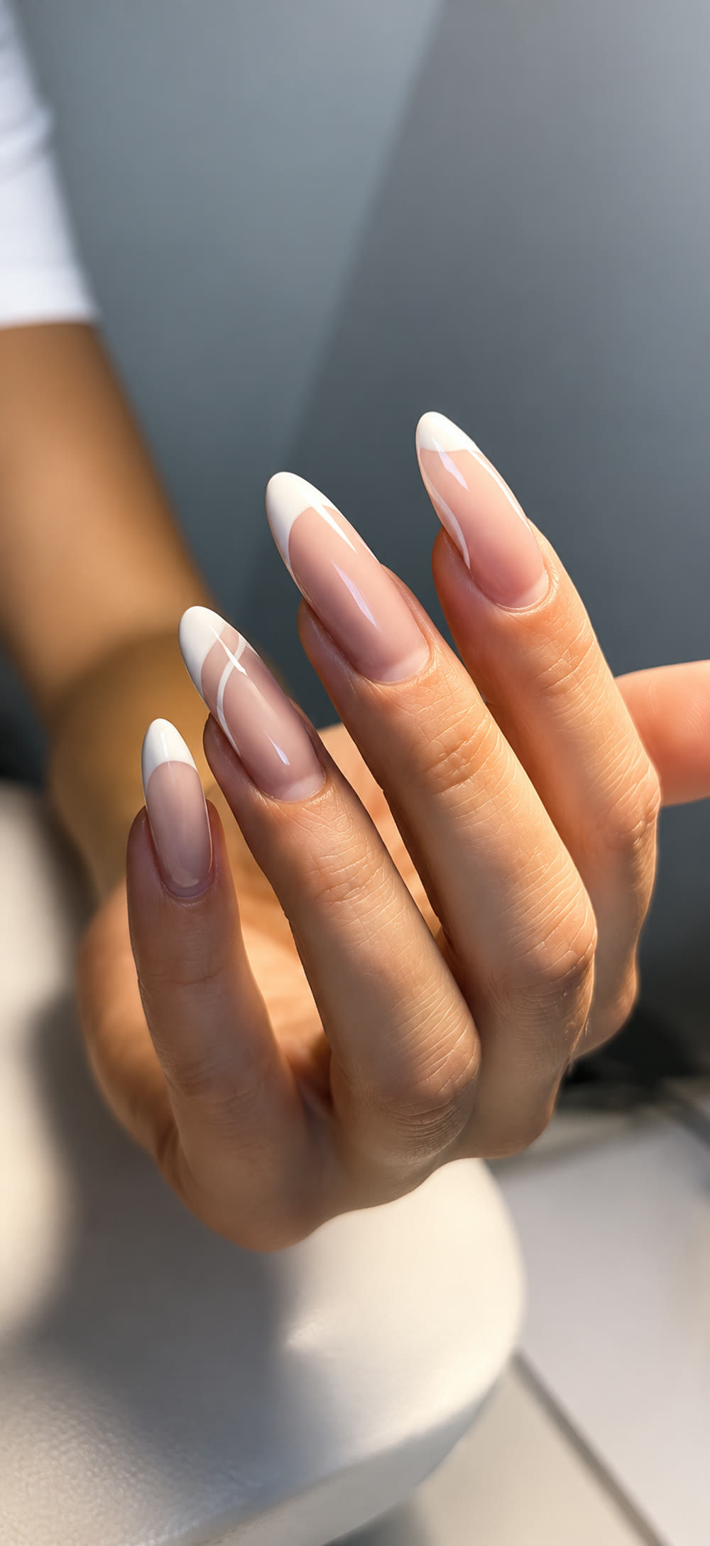 Classic French almond manicure in a soft close-up.