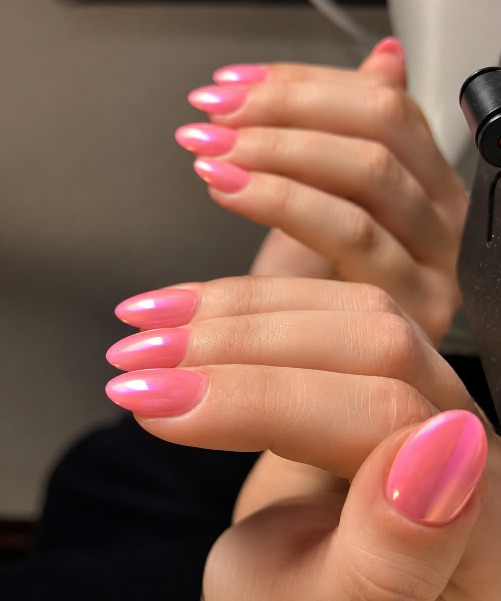 High-gloss pink manicure, two hands posed together.