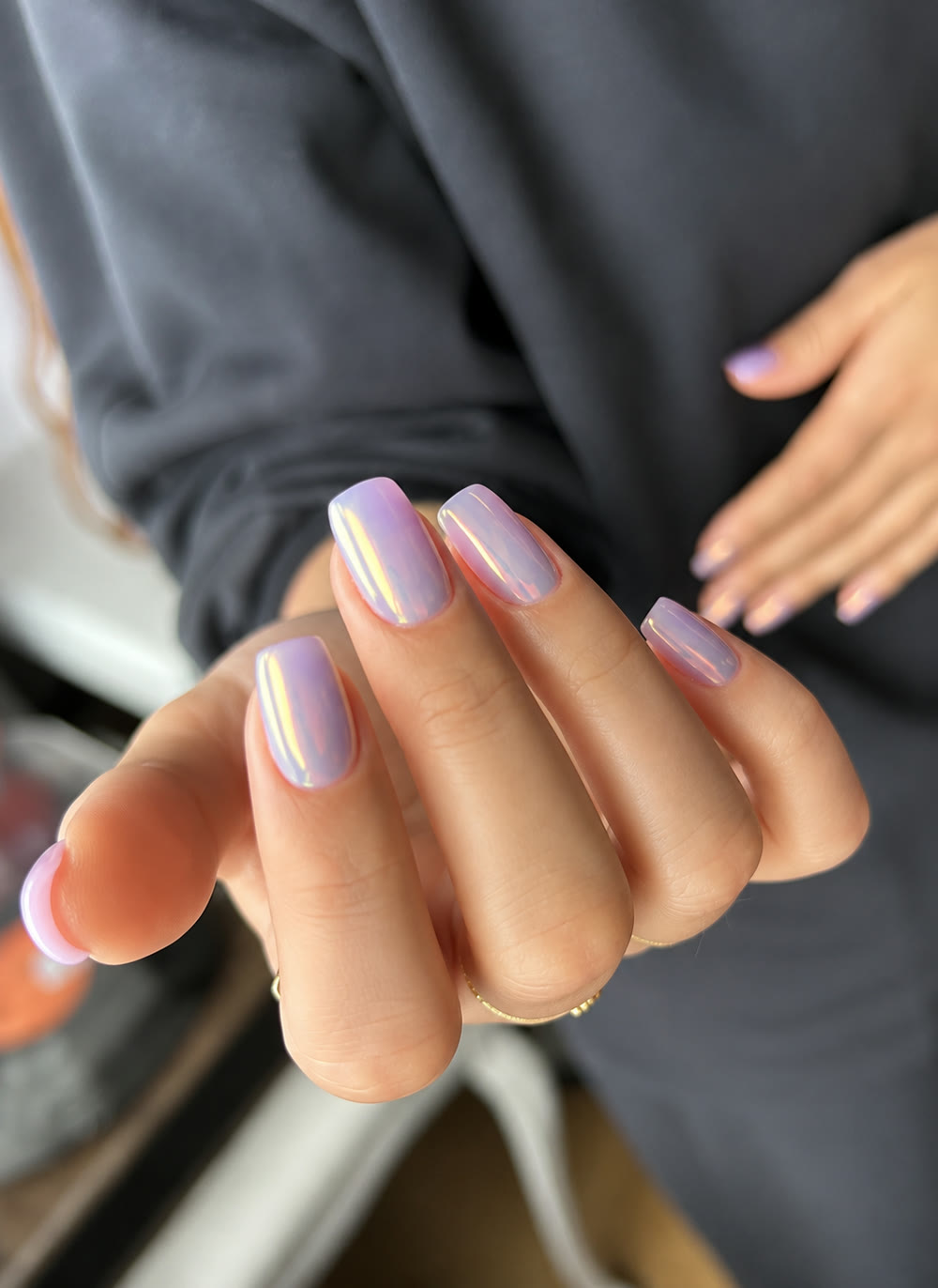 Soft pearl-pink almond nails in gentle daylight.